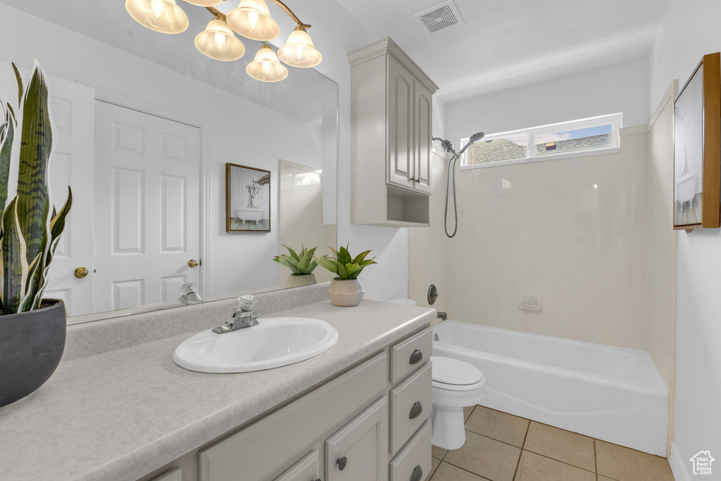 Bathroom with vanity, a chandelier, tile patterned flooring, and bathing tub / shower combination