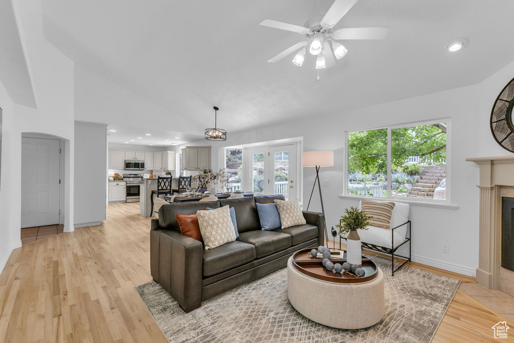 Living area with plenty of natural light, ceiling fan, lofted ceiling, light wood-style flooring, and recessed lighting