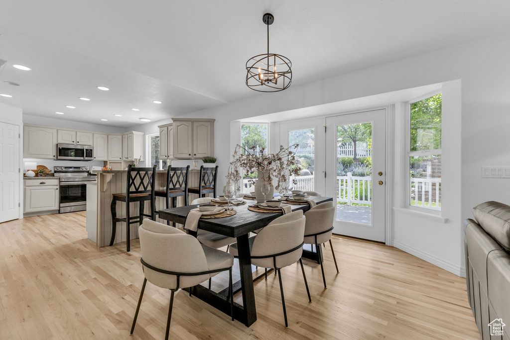 Dining area featuring light wood finished floors, recessed lighting, and a chandelier