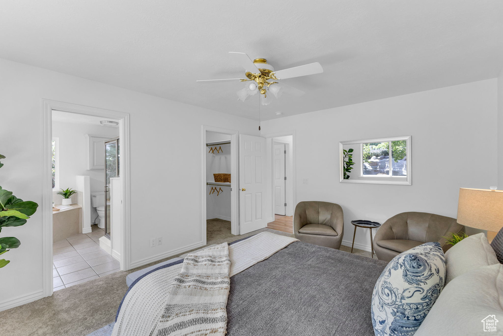 Tiled living room with a ceiling fan and carpet flooring