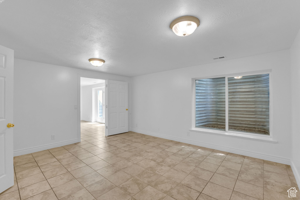 Unfurnished room featuring a textured ceiling