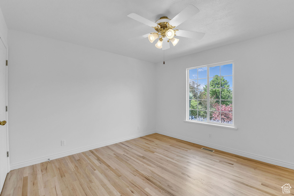 Spare room with wood finished floors and ceiling fan