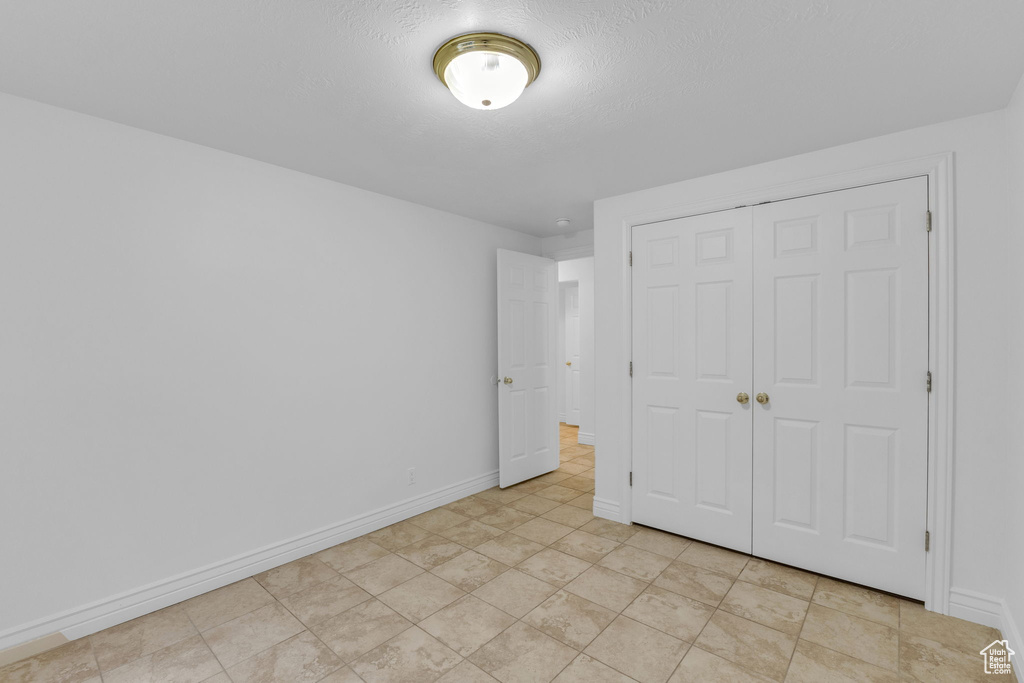 Unfurnished bedroom featuring baseboards and a closet
