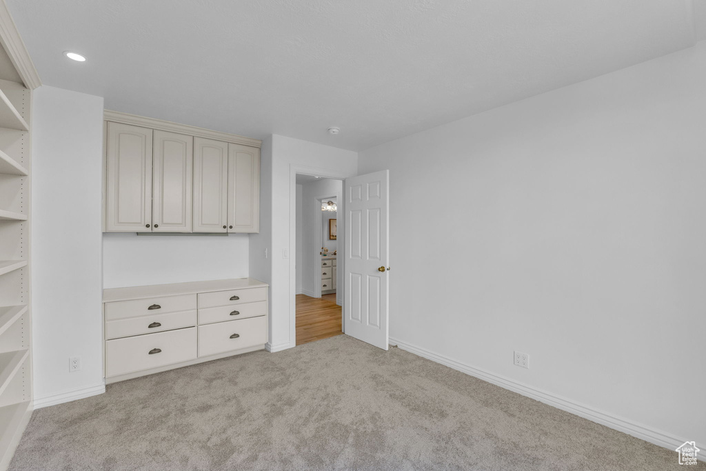Unfurnished bedroom with light colored carpet and recessed lighting
