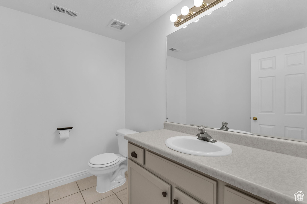 Half bathroom with vanity and tile patterned flooring