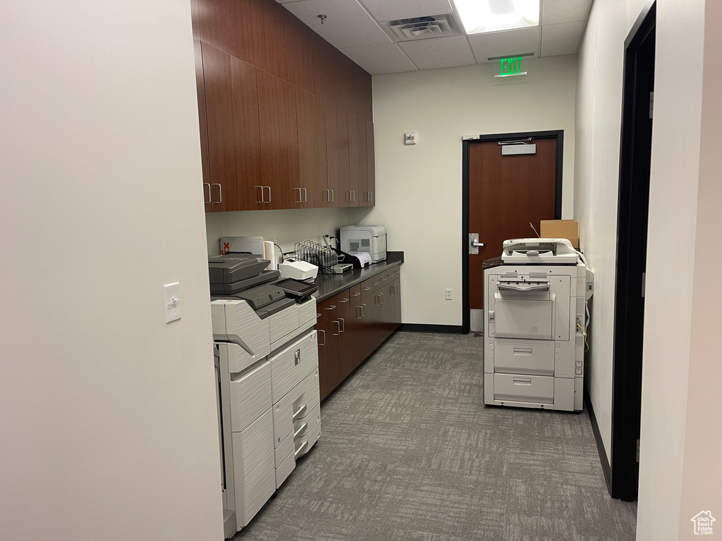 Kitchen with carpet floors, dark countertops, and a drop ceiling