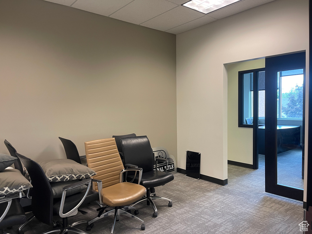 Carpeted office space with baseboards and a drop ceiling