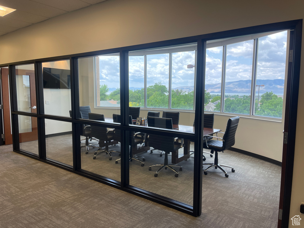 Carpeted office space with baseboards and a mountain view