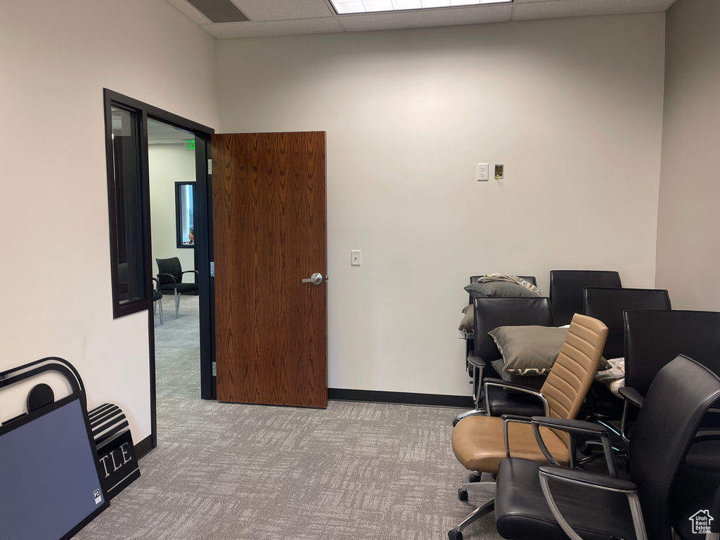 Carpeted home office with baseboards and a drop ceiling