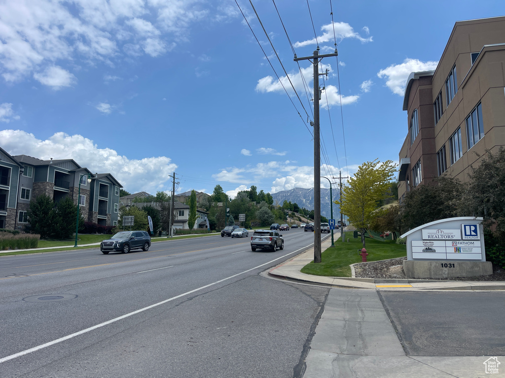 View of asphalt street featuring curbs, sidewalks, and a mountain view