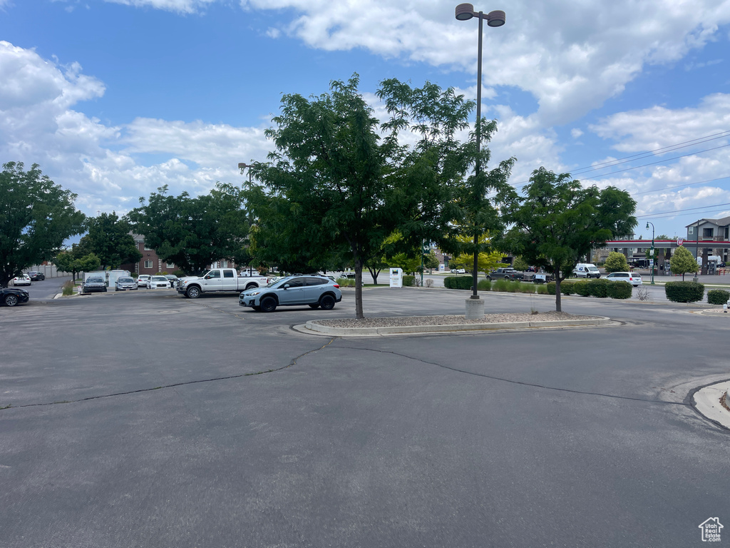 View of asphalt road with curbs, street lights, and sidewalks