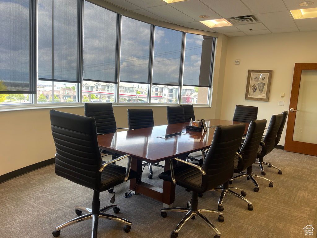 Office space with carpet floors, healthy amount of natural light, and a drop ceiling