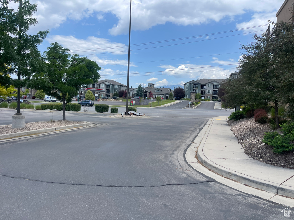 View of asphalt street featuring sidewalks, curbs, and a residential view