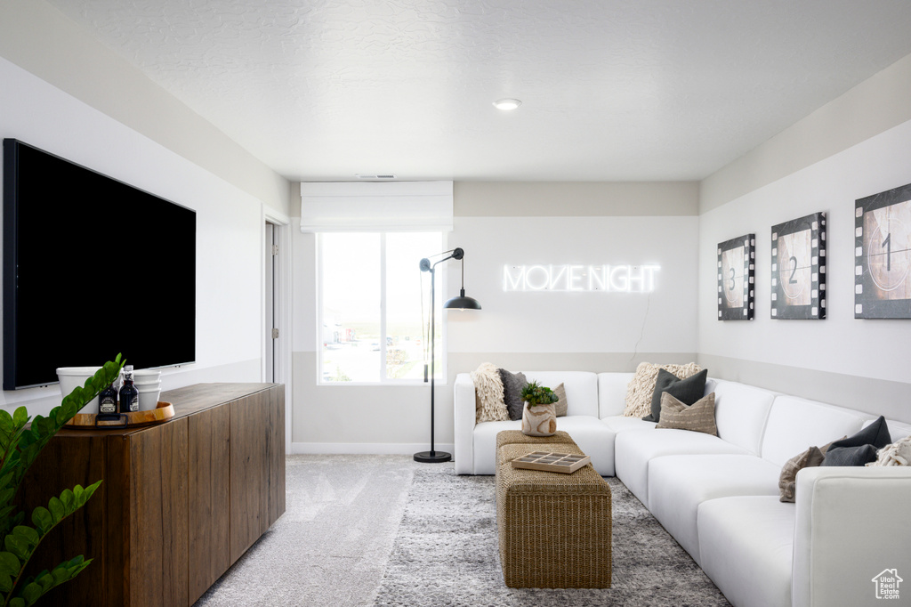 Living area featuring light colored carpet and baseboards