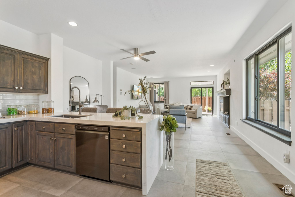 Kitchen featuring dishwasher, dark brown cabinetry, light countertops, a ceiling fan, and a peninsula