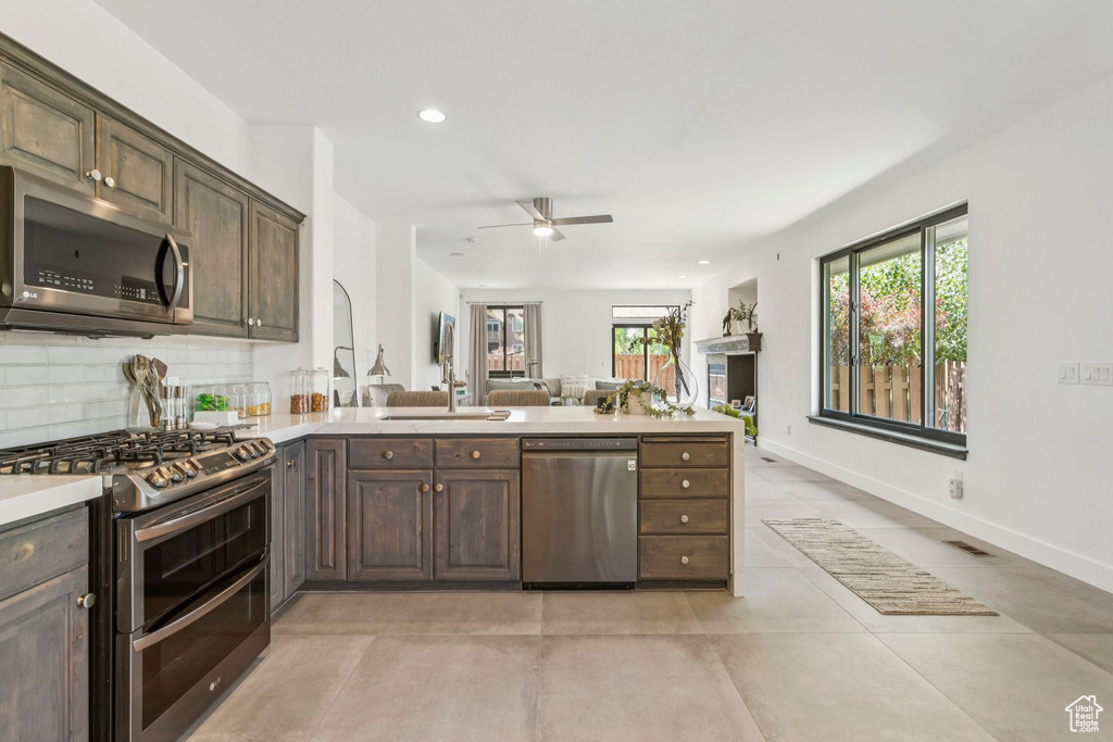 Kitchen featuring appliances with stainless steel finishes, light countertops, ceiling fan, a peninsula, and recessed lighting