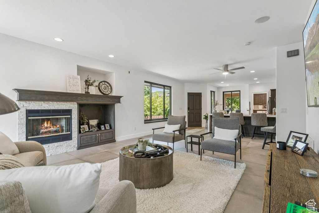 Living area with recessed lighting, healthy amount of natural light, ceiling fan, and a fireplace