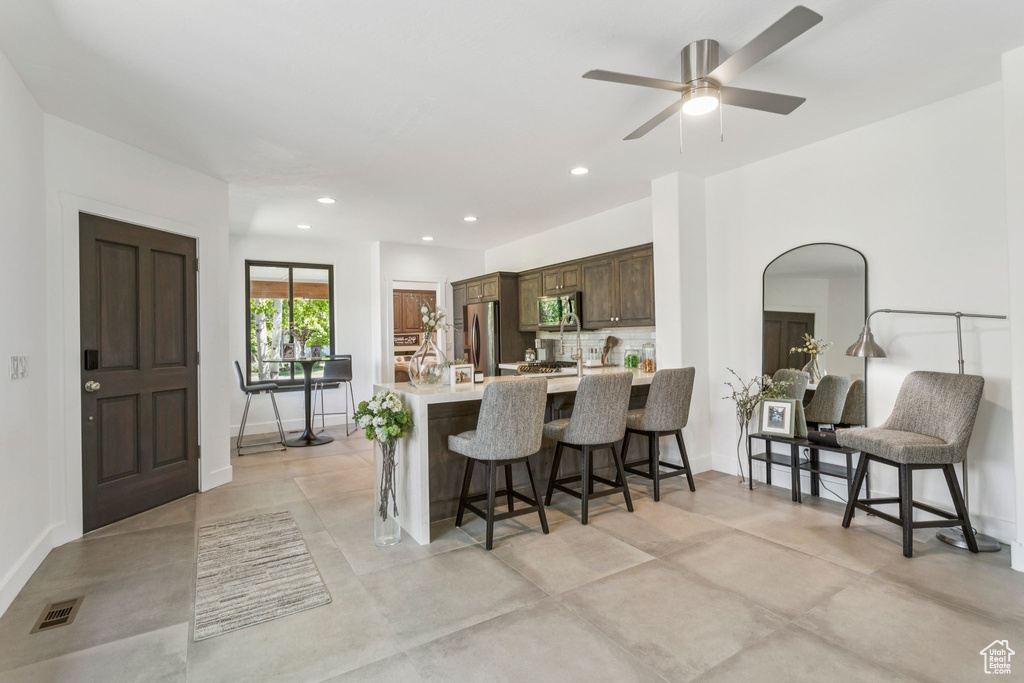 Kitchen with appliances with stainless steel finishes, light countertops, a kitchen breakfast bar, a peninsula, and ceiling fan