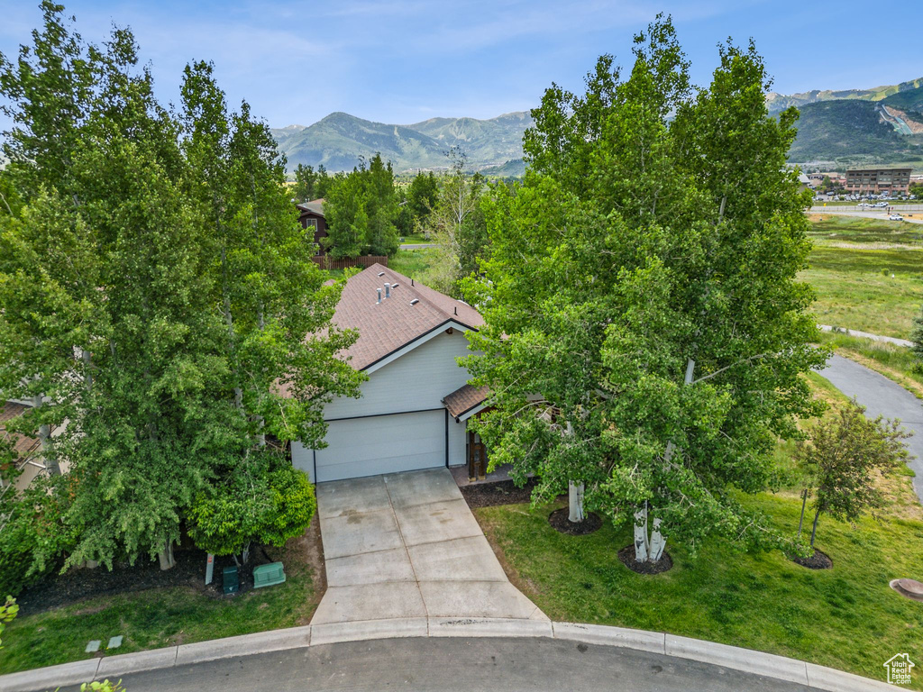 View of front of property with a mountain view, driveway, and a garage