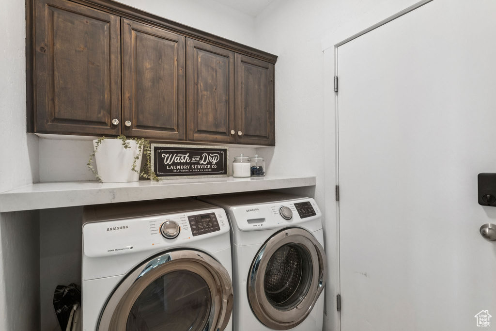 Washroom featuring cabinet space and washing machine and dryer