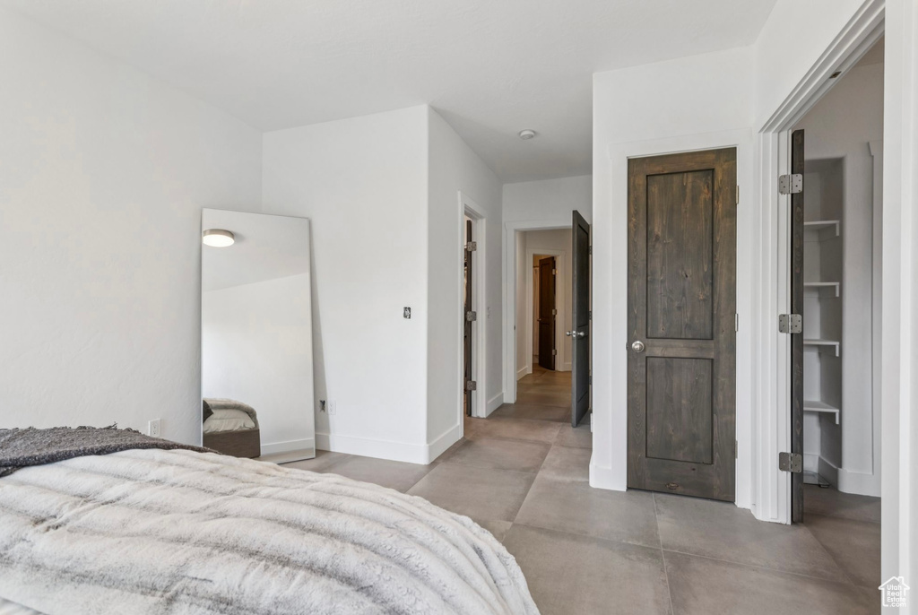 Bedroom featuring concrete floors and baseboards