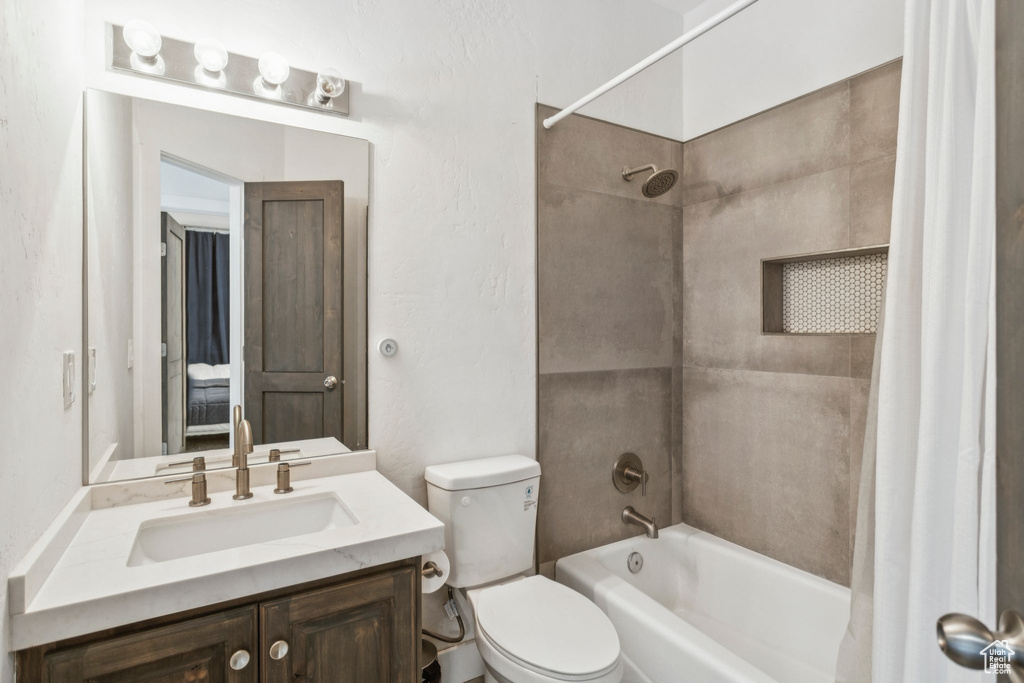 Bathroom featuring shower / bath combination with curtain and vanity