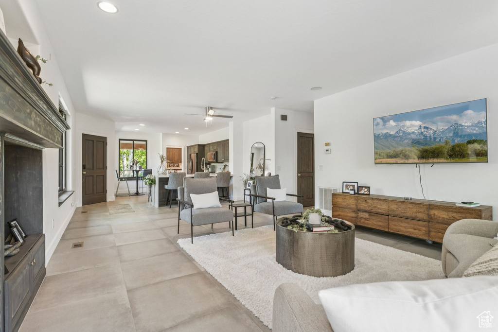 Living area with recessed lighting, a ceiling fan, and concrete flooring