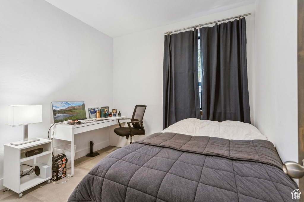 Bedroom with an office area and light carpet