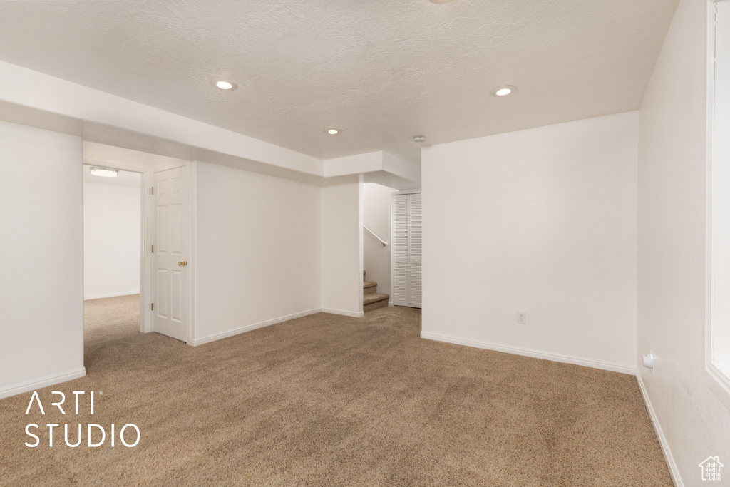 Spare room with carpet floors, stairway, recessed lighting, and a textured ceiling