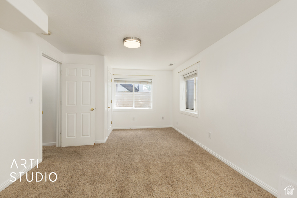 Carpeted spare room featuring baseboards