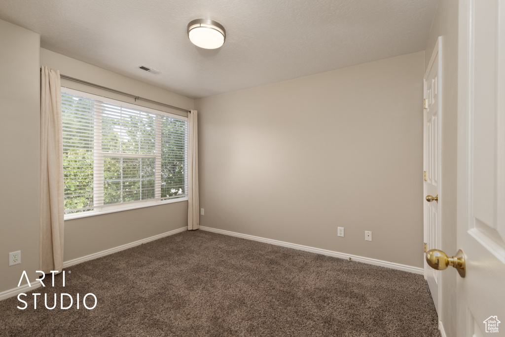Carpeted empty room featuring baseboards