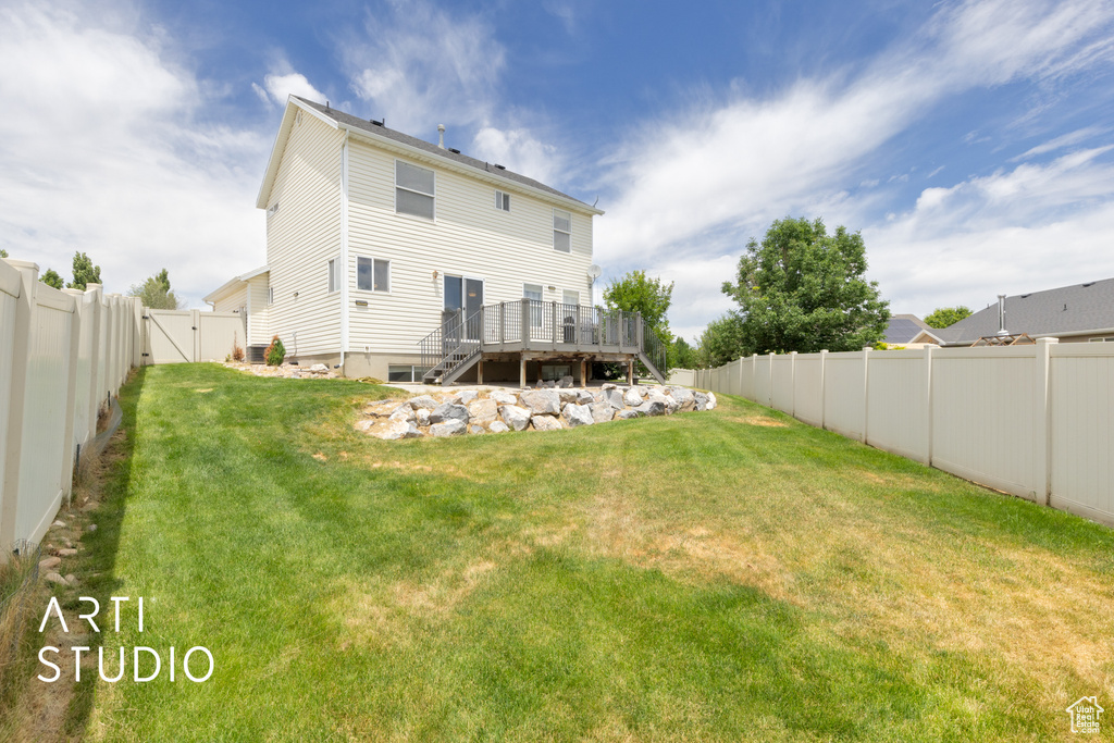 Rear view of house featuring a wooden deck, a fenced backyard, a gate, and stairway