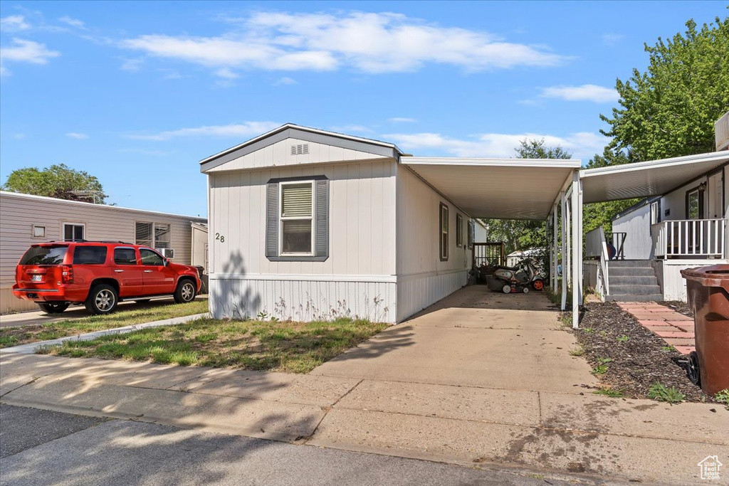 Manufactured / mobile home with concrete driveway and an attached carport