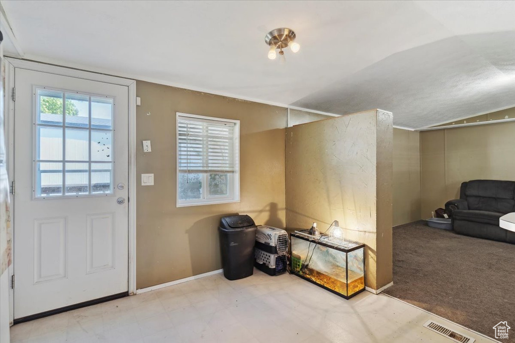 Foyer entrance with vaulted ceiling and baseboards