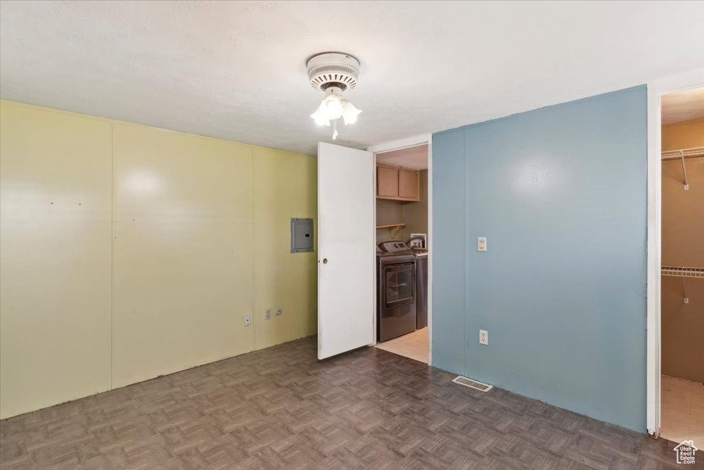 Spare room with independent washer and dryer, electric panel, and a ceiling fan