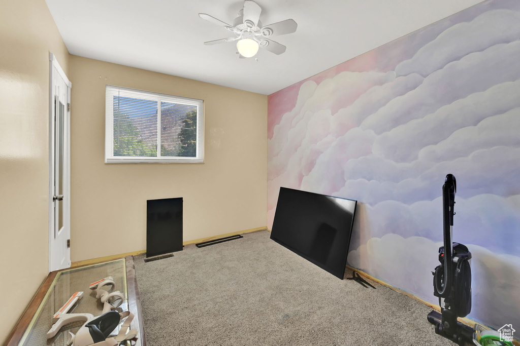 Carpeted bedroom featuring a ceiling fan