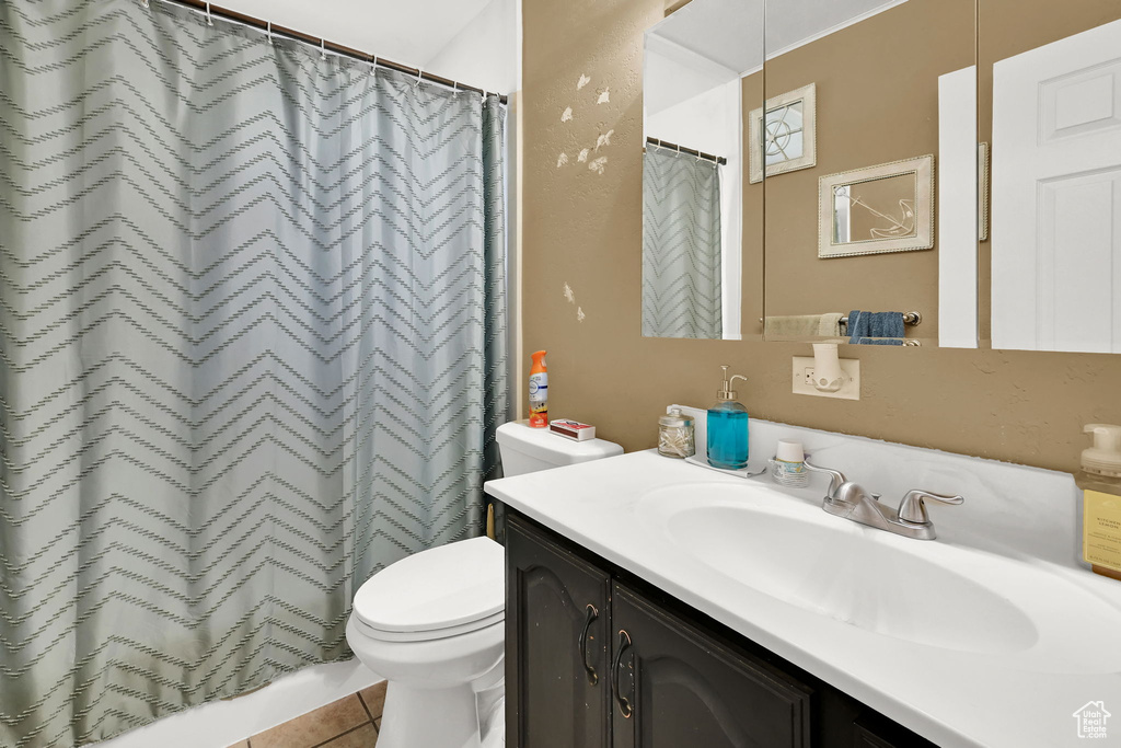 Bathroom featuring vanity, tile patterned flooring, and curtained shower