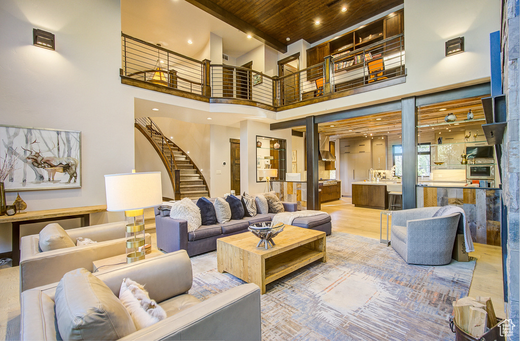 Community lobby featuring a wooden ceiling with exposed beams, a towering ceiling, stairway, and recessed lighting