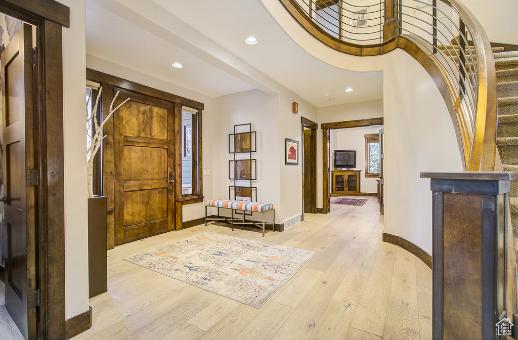 Entryway with recessed lighting, light wood-style floors, and stairs
