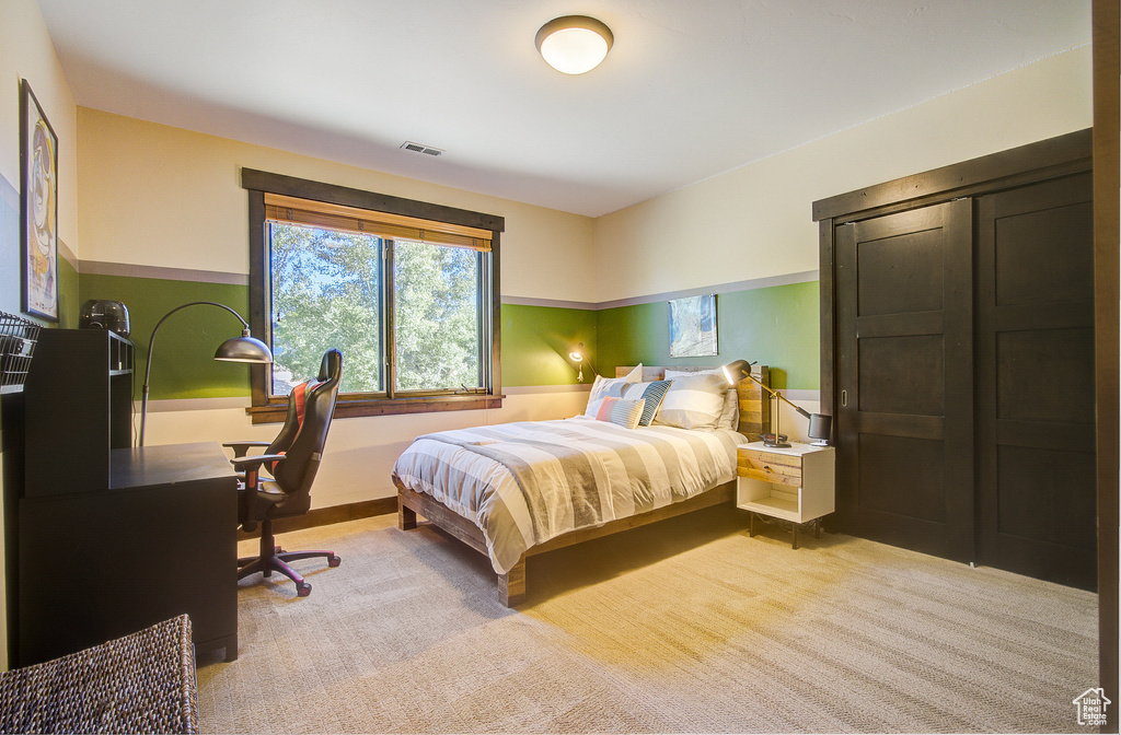 Bedroom featuring light colored carpet
