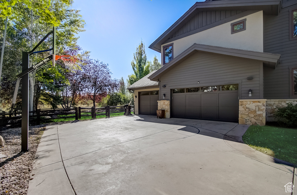 View of side of property with stone siding and concrete driveway