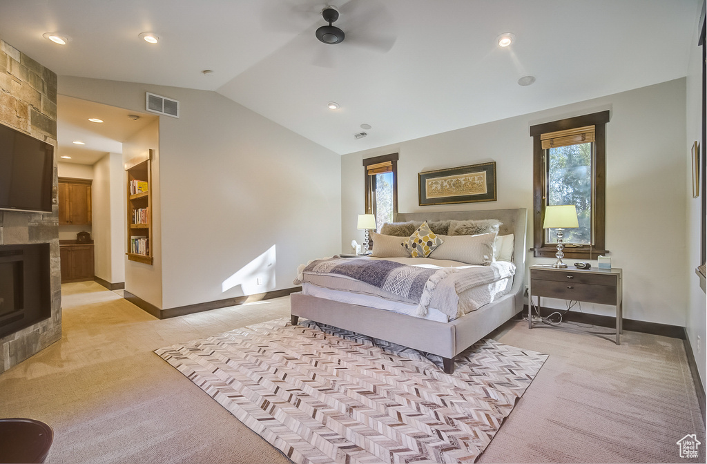Bedroom with light carpet, vaulted ceiling, and a ceiling fan