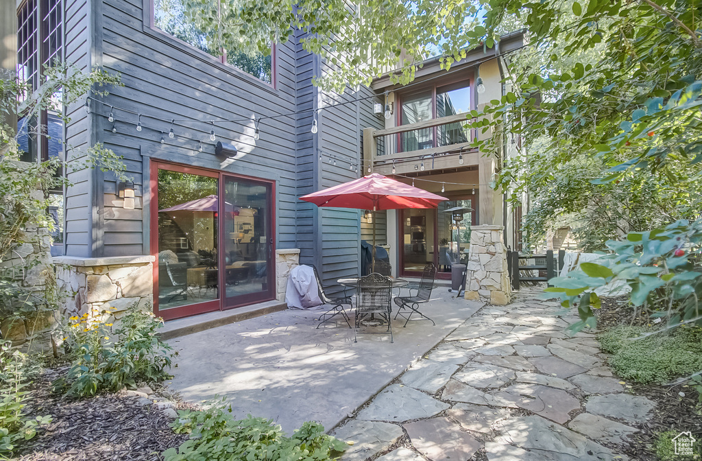 Rear view of property featuring a balcony and a patio area