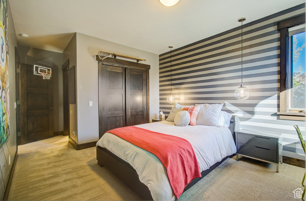 Bedroom featuring light carpet, a closet, and wallpapered walls