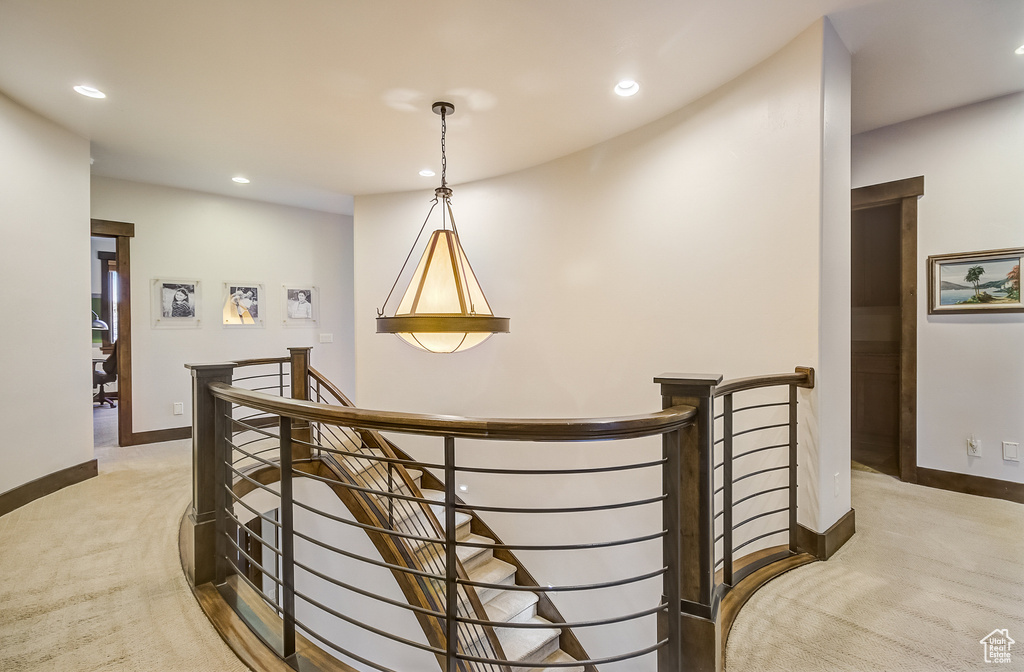 Corridor with an upstairs landing, light colored carpet, and recessed lighting