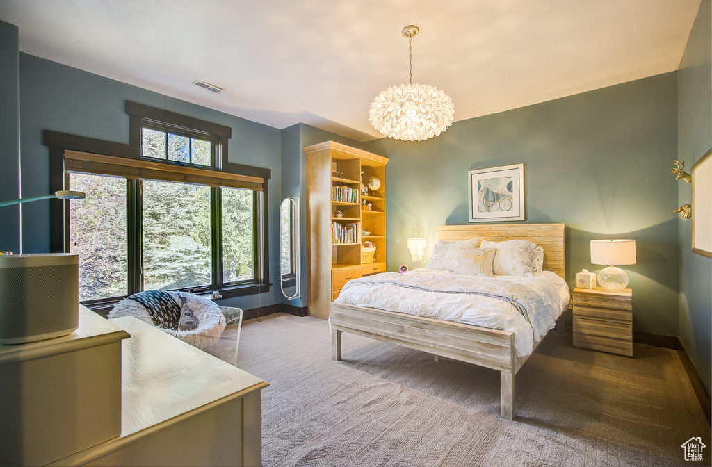 Bedroom featuring a chandelier and carpet