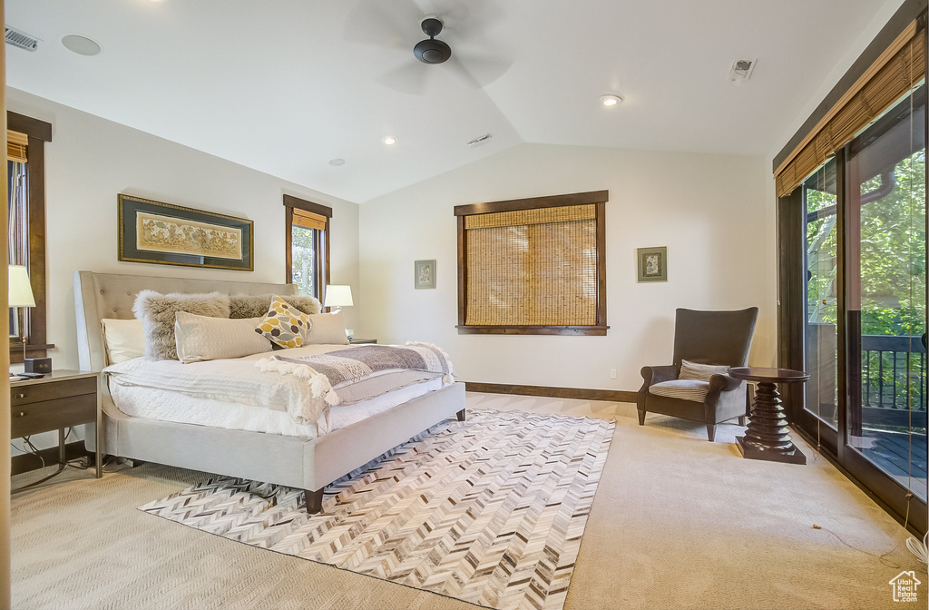 Bedroom featuring vaulted ceiling, access to exterior, multiple windows, light carpet, and ceiling fan