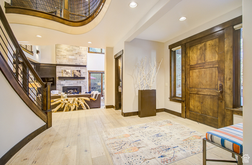 Entrance foyer with hardwood / wood-style flooring, a fireplace, recessed lighting, and stairs