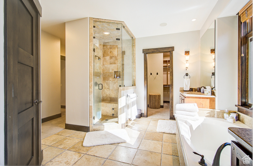 Full bathroom featuring vanity, a stall shower, and stone tile floors