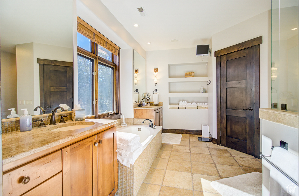 Bathroom with two vanities and a bath